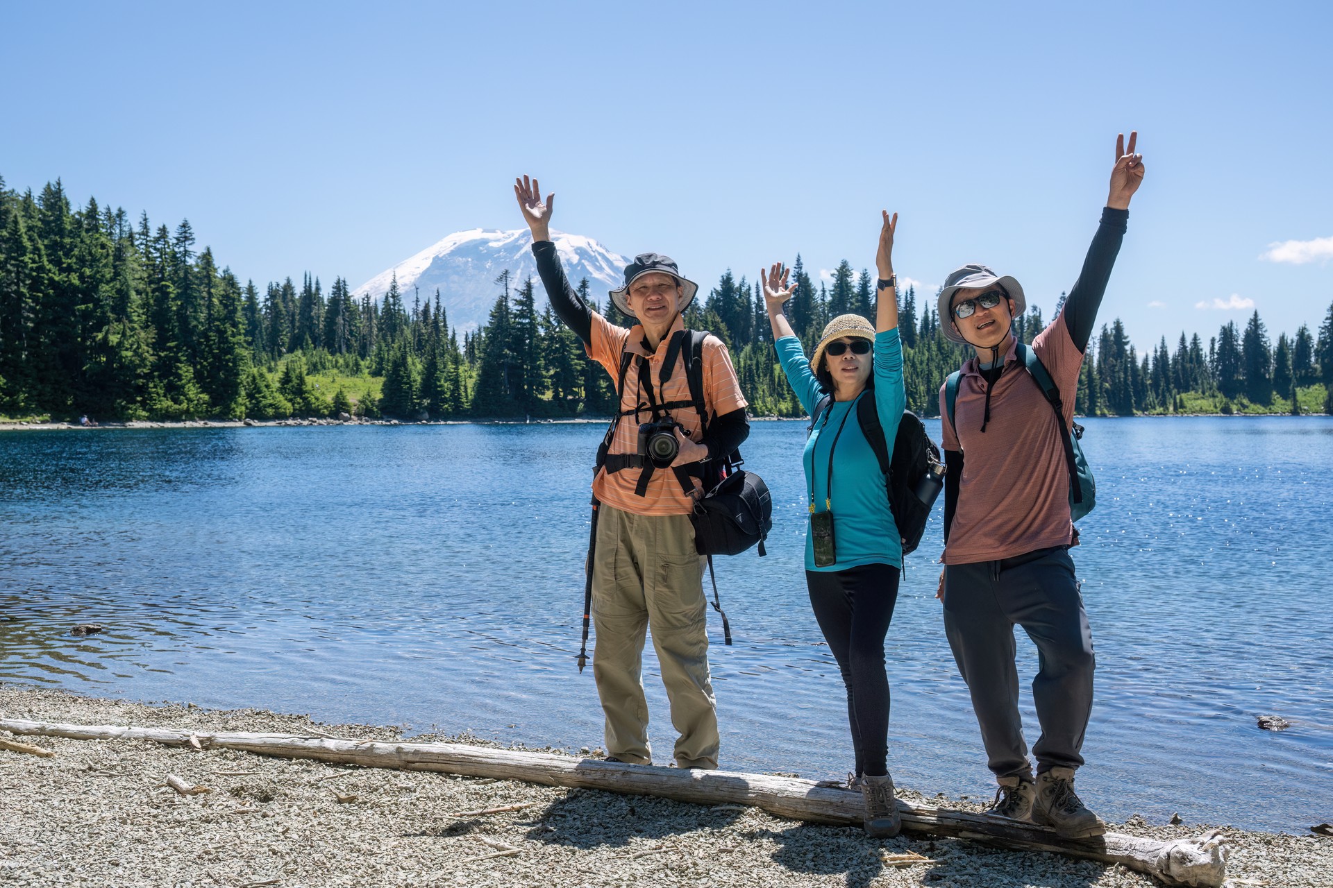 Tourists posing for photos by Summit Lake. Mount Rainier in the background. Mount Rainier National Park. Washington State.